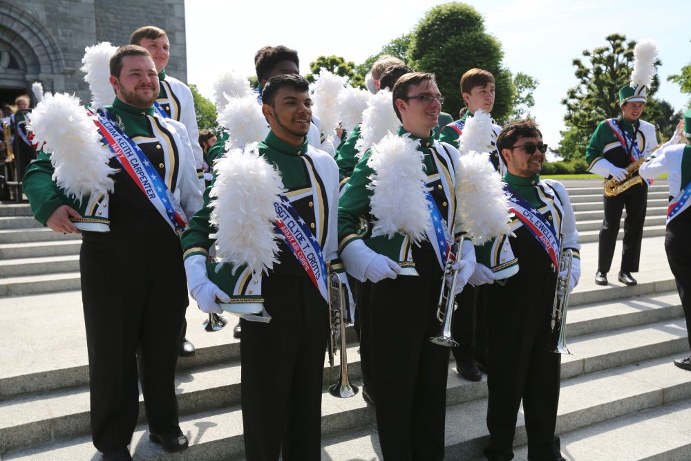 PNNMB trumpet section on the steps of the chapel at the Brittany American Cemetery in Normandy, France. Each band member is wearing a sash in memory or in honor of a Veteran from any war at each performance while in France.
